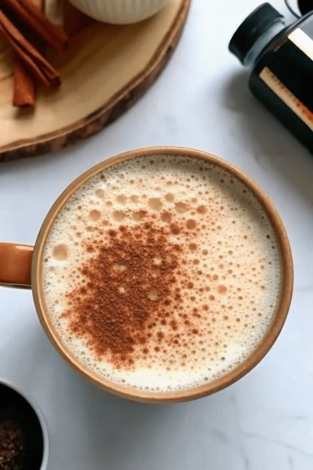 collagen latte sprinkled with cinnamon in orange ceramic mug